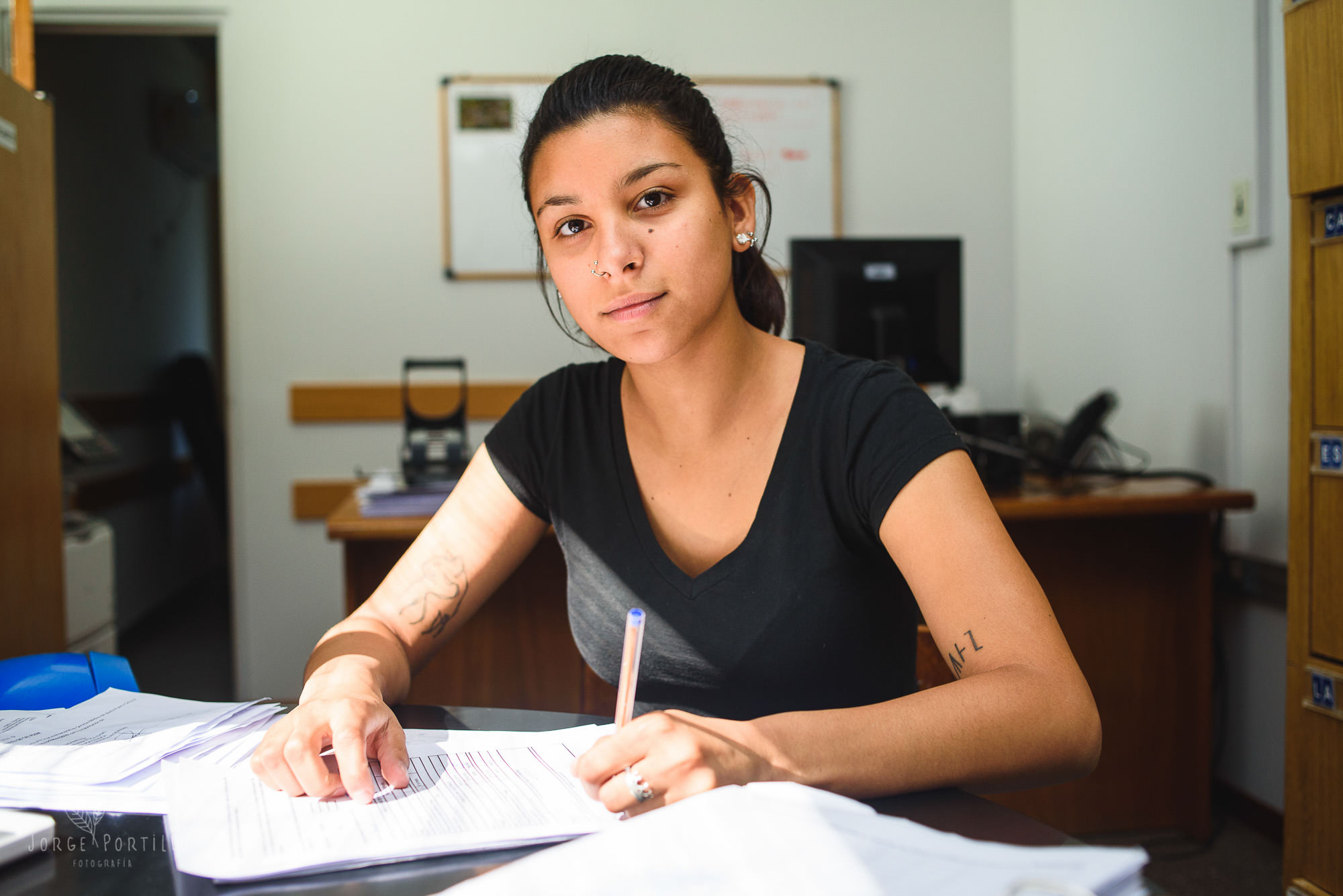 Profesional revisa documentos en oficina, reflejando el avance de proyectos personales virtuales.