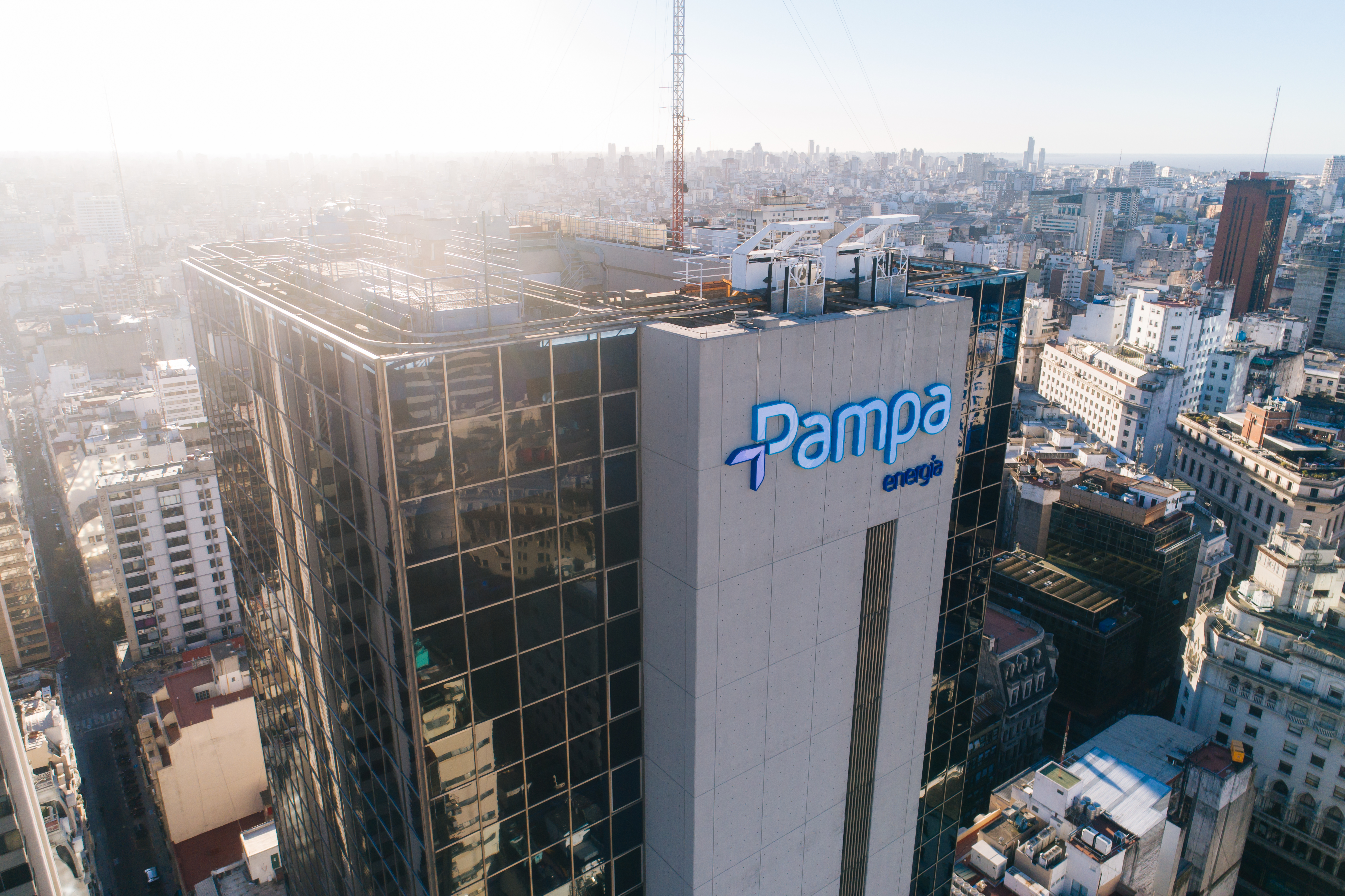Pampa Energía anuncia sus logros del 2024 con una vista aérea de su edificio corporativo en una ciudad.