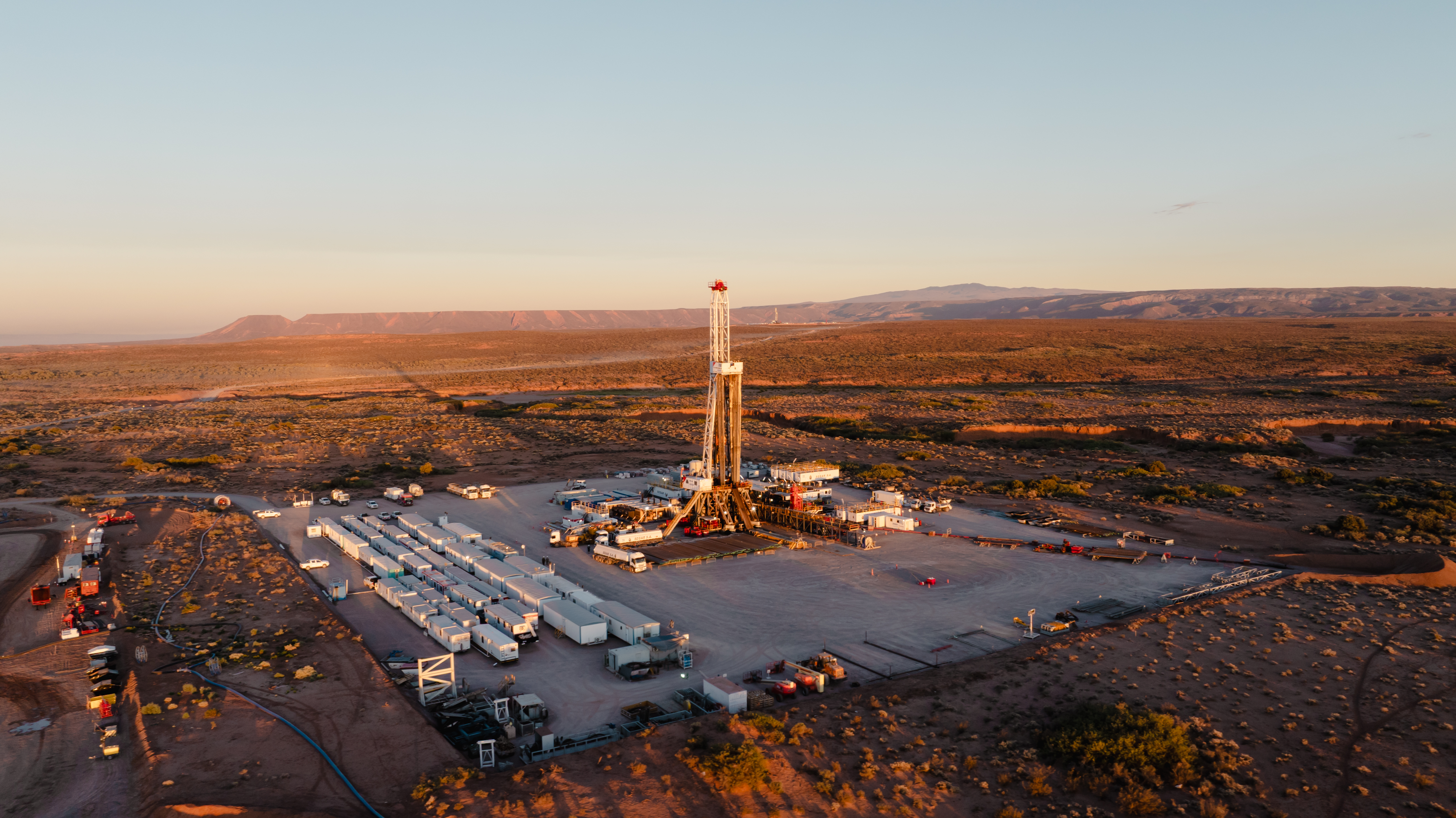 Pampa Energía se asocia con Southern Energy en un proyecto energético en un paisaje desértico con instalaciones industriales al atardecer.